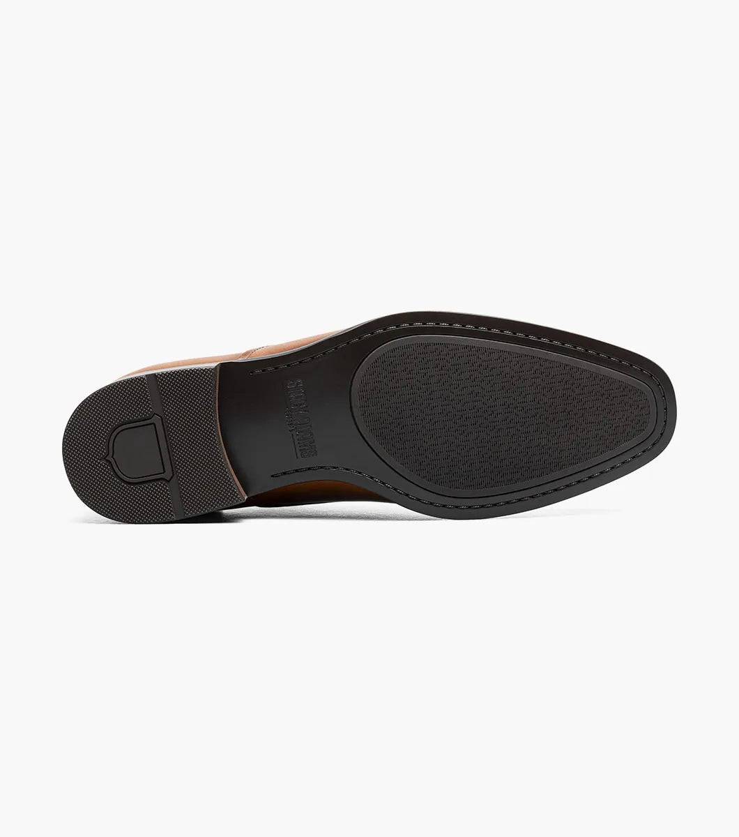 Introducing the STACY ADAMS Langford Plain Toe Oxford in Cognac (25795-221), a men’s dress shoe featuring a rich brown leather upper, subtle decorative perforations on the toe, a low stacked heel, and classic closed lacing. Shown against a white background, these Stacy Adams Oxfords combine timeless sophistication with lasting comfort.