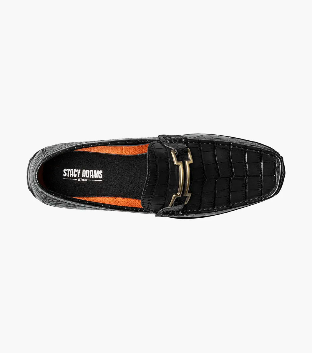 The STACY ADAMS Embrey Moc Toe Bit Slip On (25703-001) is a black leather loafer featuring a crocodile-textured upper and gold metal bit detail, shown in a side profile view.