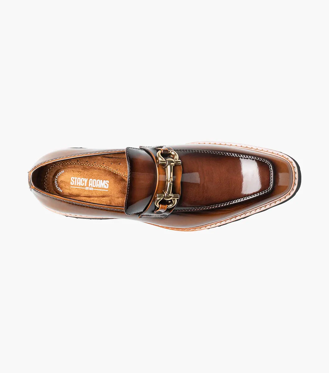 Introducing the Stacy Adams Carabello Moc Toe Bit Slip On in Brown Multi (style 25804-249), this loafer features brown leather with a shiny finish, a gold metal bit detail on the front, contrast stitching, and a black rubber sole. Designed by STACY ADAMS, it offers all-day comfort thanks to its cushioned Memory Foam insole.