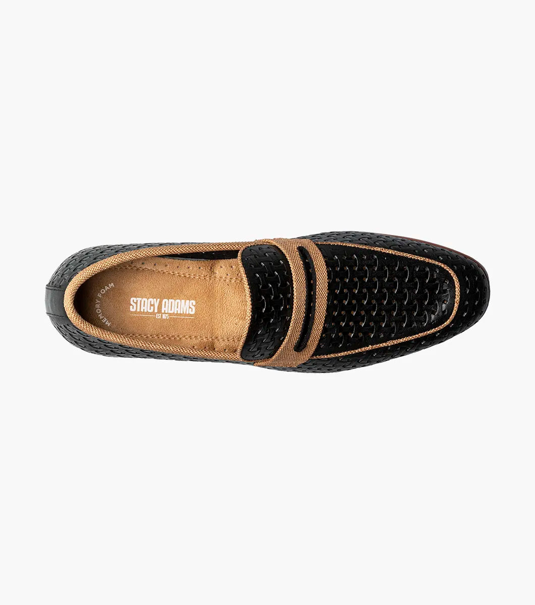 The STACY ADAMS Winstead Moc Toe Saddle Slip On (Black, 25704-001) is a black perforated leather loafer with tan accents, a low heel, brown sole, and FlexZone footbed for comfort, shown in side profile on a white background.