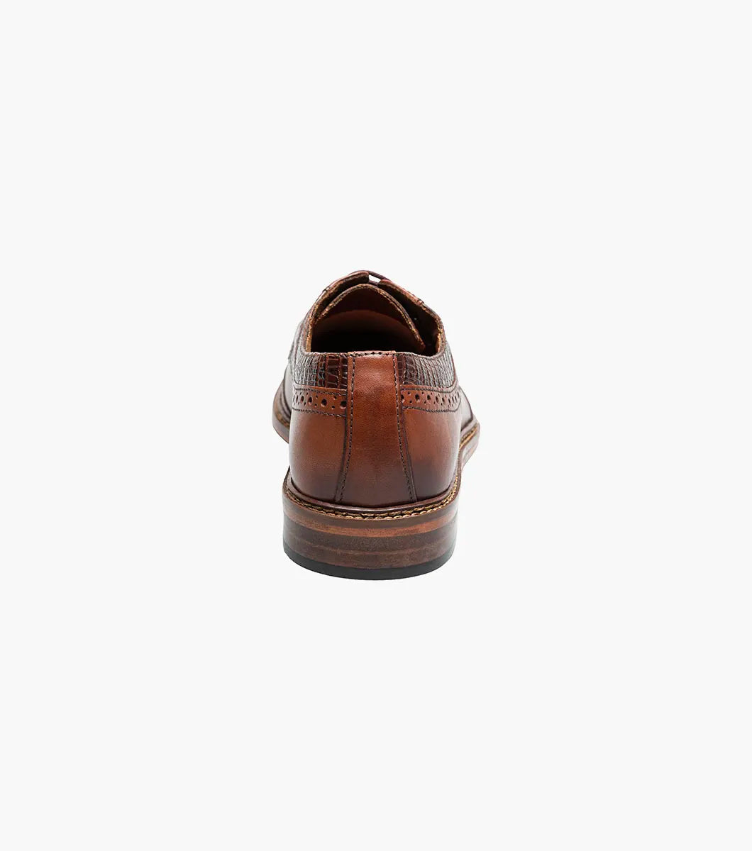 The Stacy Adams Gambetta Modified Cap Toe Oxford in cognac features textured detailing, lace-up closure, and a low heel, displayed on a white background.