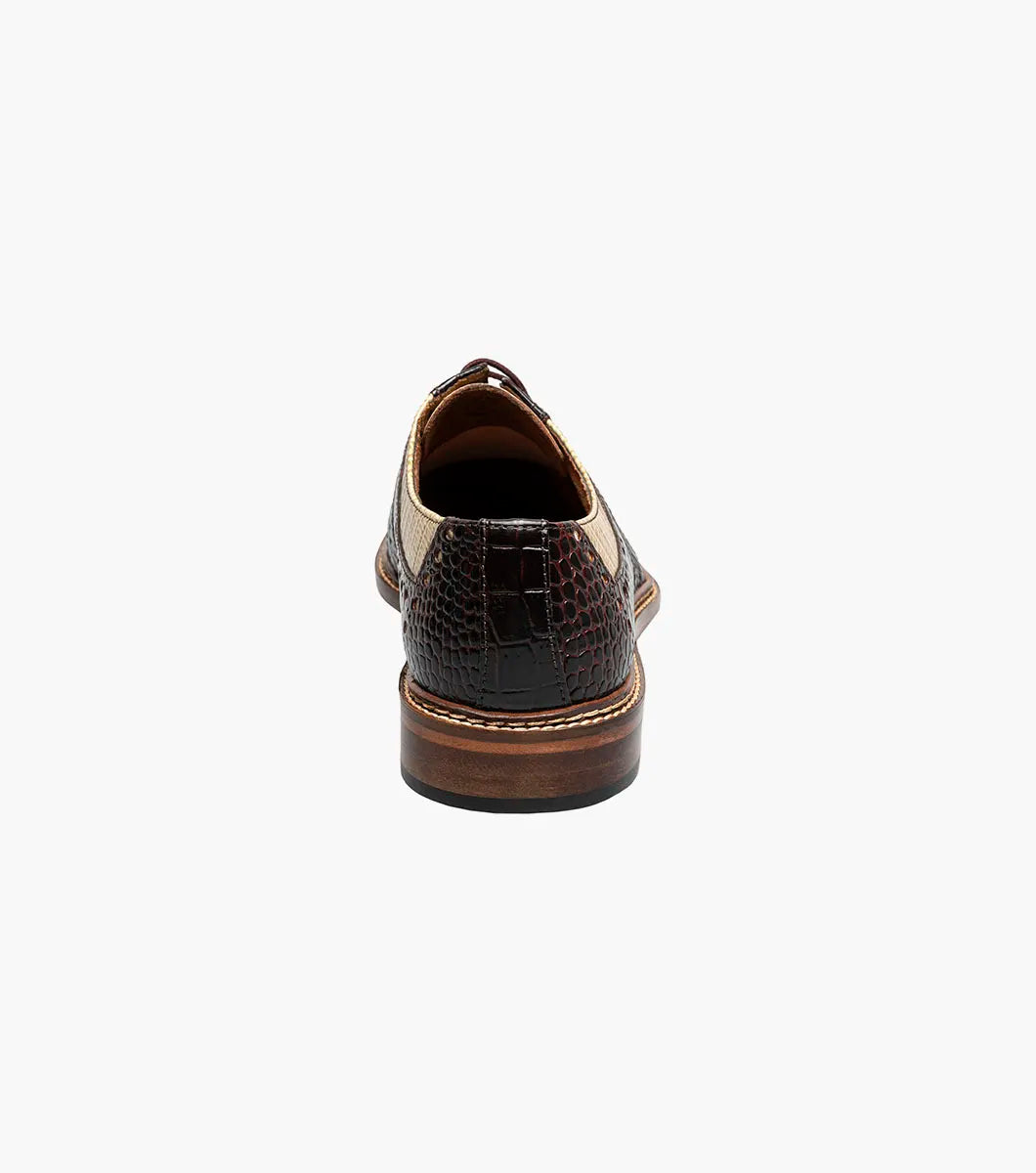The Stacy Adams Travato Wingtip Oxford (Taupe Multi, 25737-261) features a two-tone design with a tan textured leather upper, dark brown crocodile-patterned sides and toe, laces, arch support, and a low wooden heel.