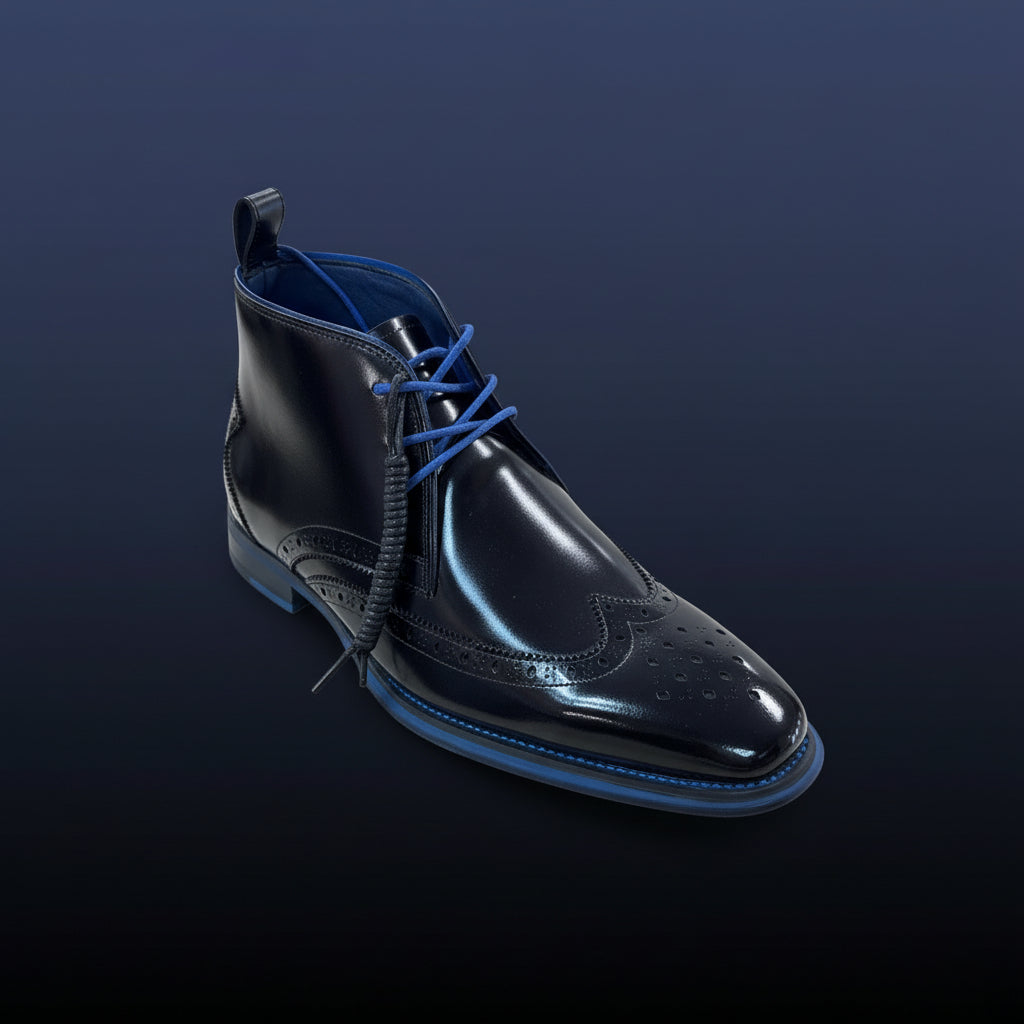The GIOVANNI Trev Wingtip Black Boot—a genuine leather dress shoe featuring bold blue colorblock trim and matching blue laces—is showcased on a wooden surface in-store, with folded clothes visible in the background.