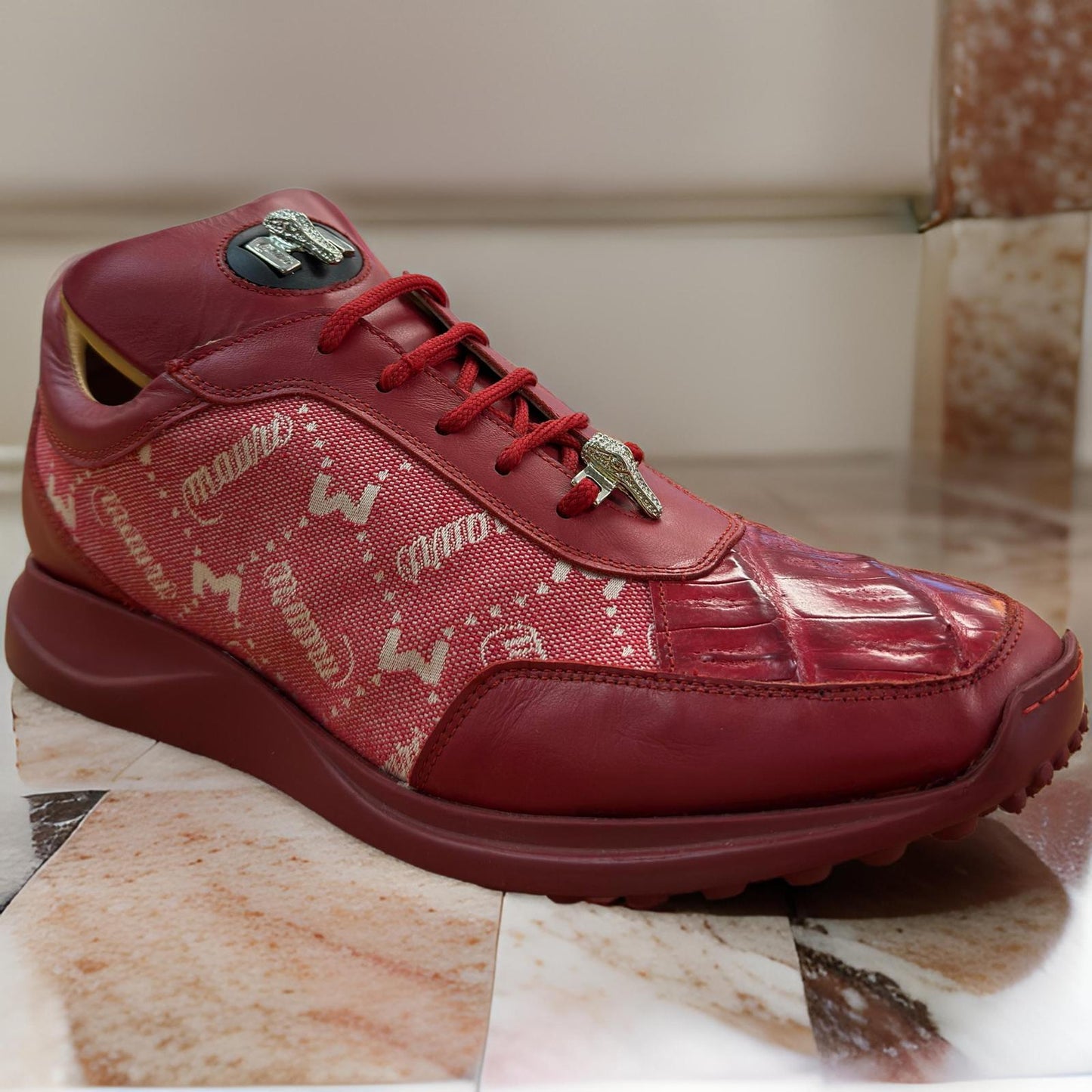 Discover the Mauri 8741, a uniquely designed red sneaker featuring leather and patterned fabric. With laces and a metallic bee detail on the tongue, it offers an exquisite touch to this custom-crafted shoe from Mauri. Available in-store for final sale only.