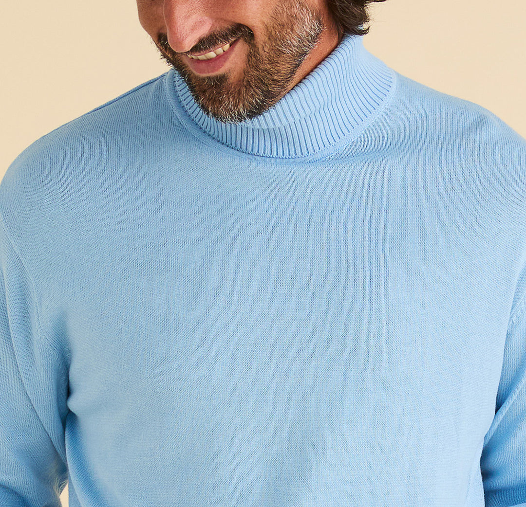 A bearded man smiles, wearing an Inserch Cotton Blend Slim Fit Turtleneck Sweater in Blue Mist, shown from shoulders to mid-chest.