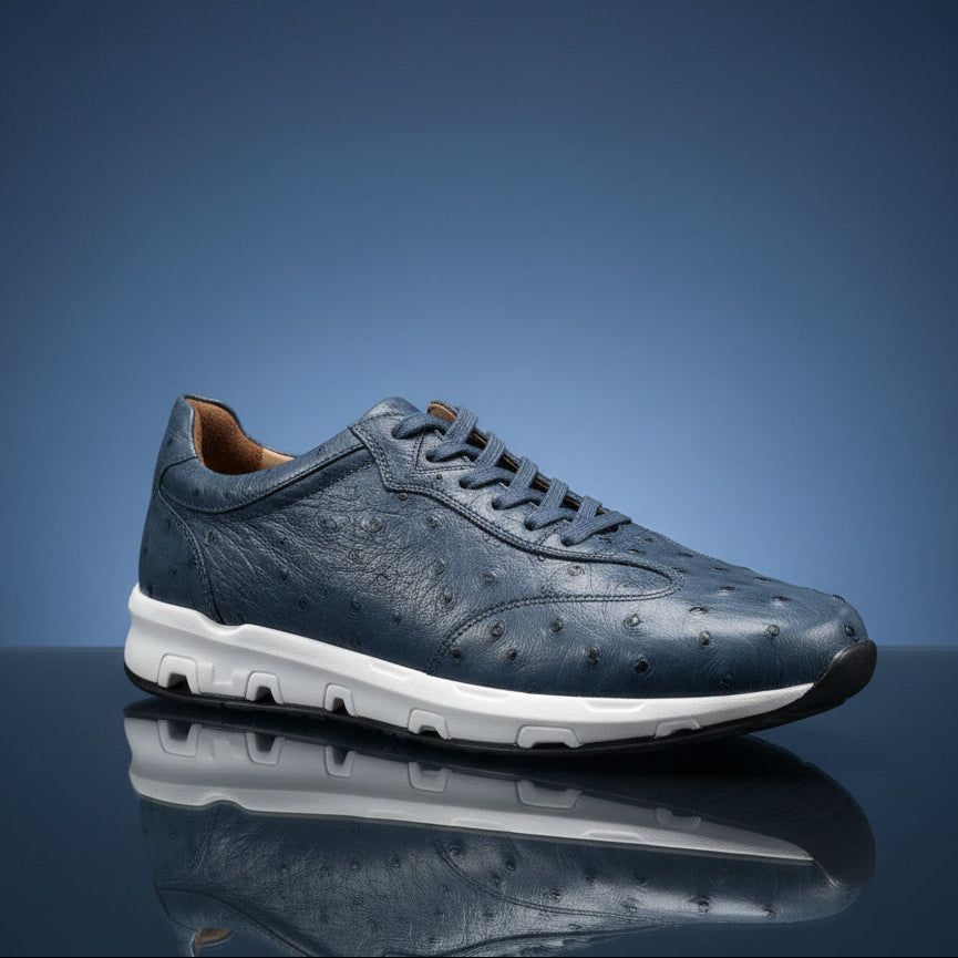 A Belvedere Shoe 10 in size 8.5 (FINAL SALE) by BELVEDERE is displayed on a wooden surface in a store setting. This dark blue textured sneaker features a white sole and is final sale—no returns or exchanges available.