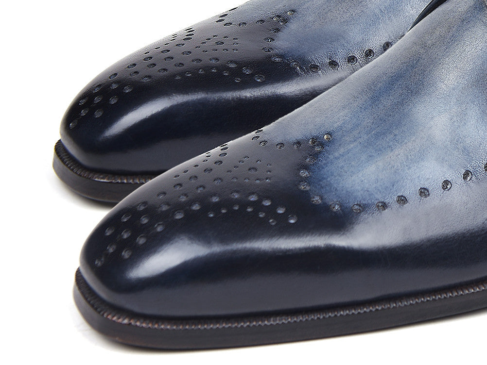 The Paul Parkman Wingtip Single Monkstraps Navy - 98F54-NVY are handmade navy leather shoes with wingtip perforations and a buckle closure, displayed on a white background.