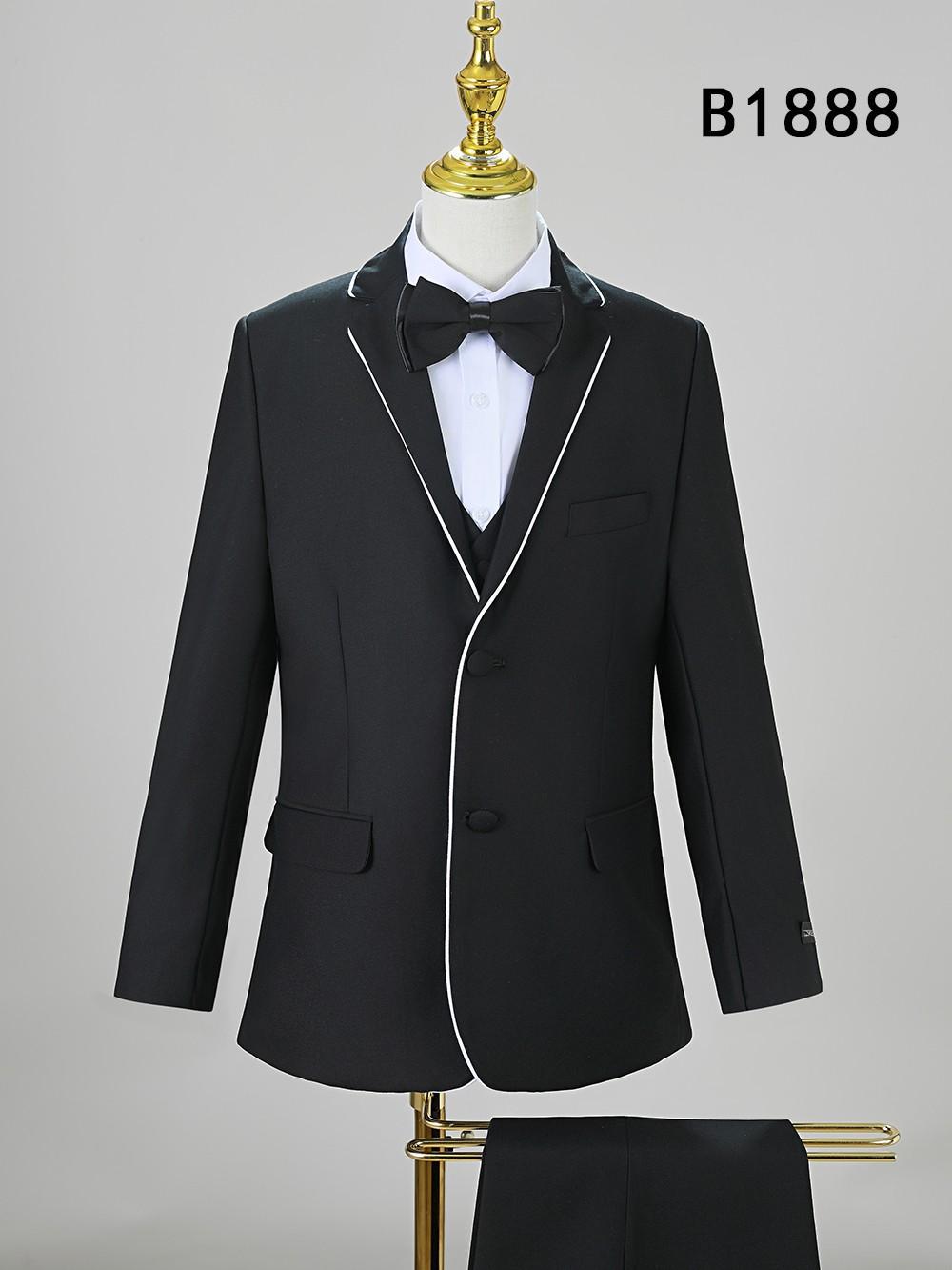 The Unique Design Menswear BOY SUIT 5-PC SET B1888 features a black suit with white piping, matching waistcoat, white shirt, and black bow tie on a mannequin. "B1888" is shown at the top right—ideal formal wear for boys’ special occasions.