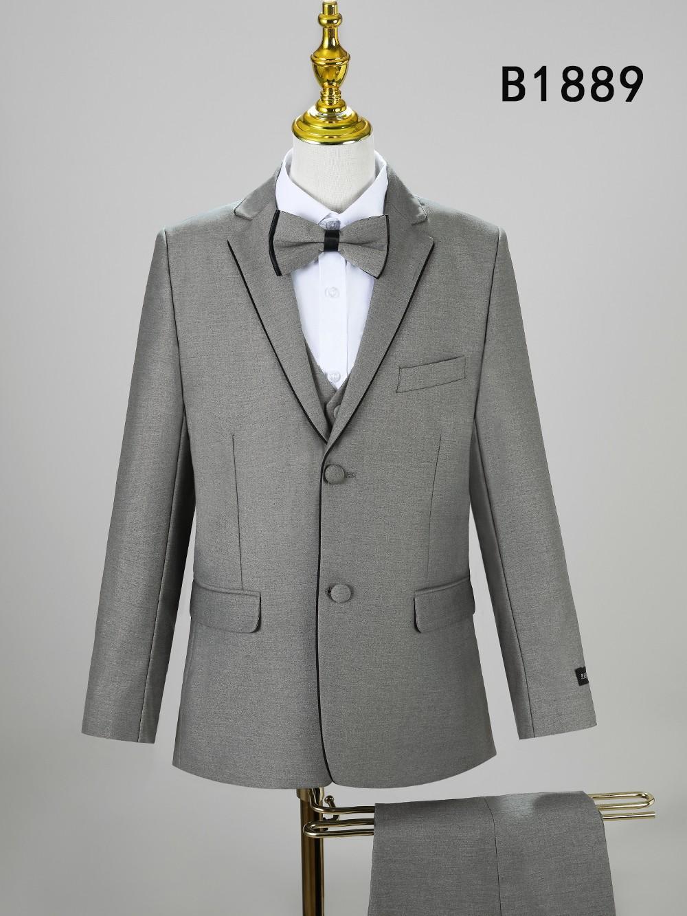 The Unique Design Menswear BOY SUIT 5-PC SET B1889 features a stylish gray three-piece suit with bow tie, ideal for boys’ formal wear. Displayed on a mannequin with pants below and code B1889 in the top right corner.
