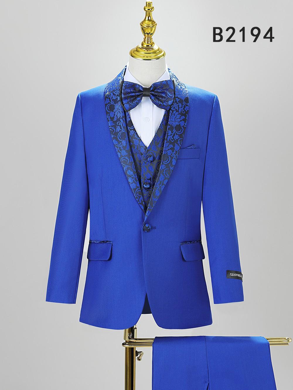 The BOY SUIT 5-PC SET B2194 by Unique Design Menswear features a royal blue jacket with patterned lapel, matching vest, bow tie, white shirt, and pants—stylish boys formal wear for any special occasion. "B2194" is labeled in the corner.