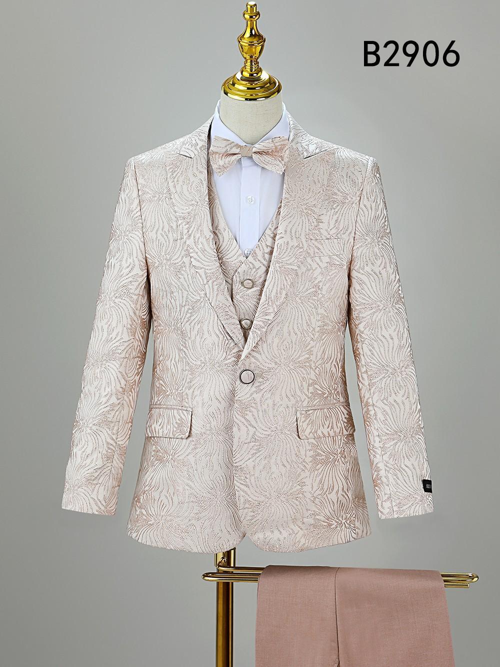 The BOY SUIT 5-PC SET B2906 by Unique Design Menswear features a light beige suit with subtle floral pattern, matching bow tie and trousers, displayed on a mannequin. "B2906" is shown in the top right corner.