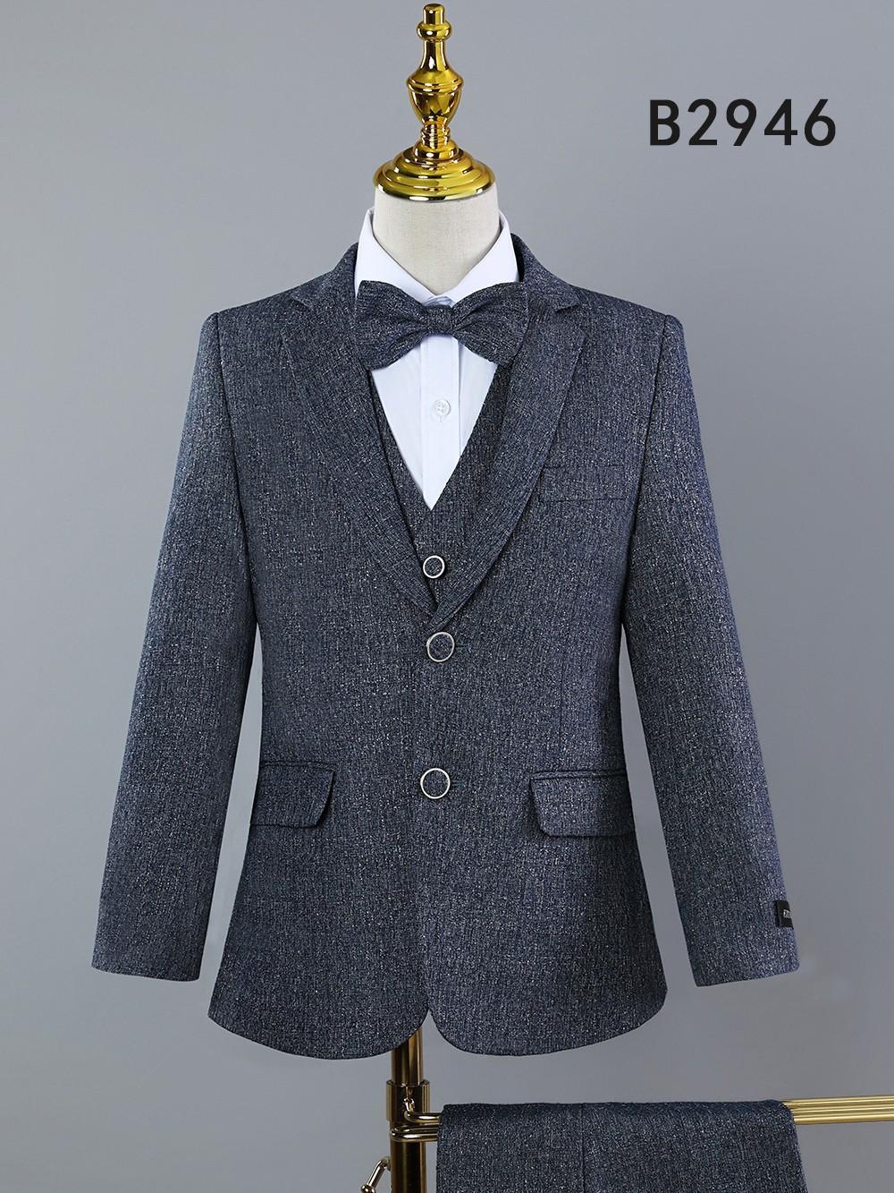 A BOY SUIT 5-PC SET B2946 by Unique Design Menswear, in gray with notch lapel, white shirt, bow tie, and two front pockets, is displayed on a mannequin. "B2946" is shown in the top right corner.