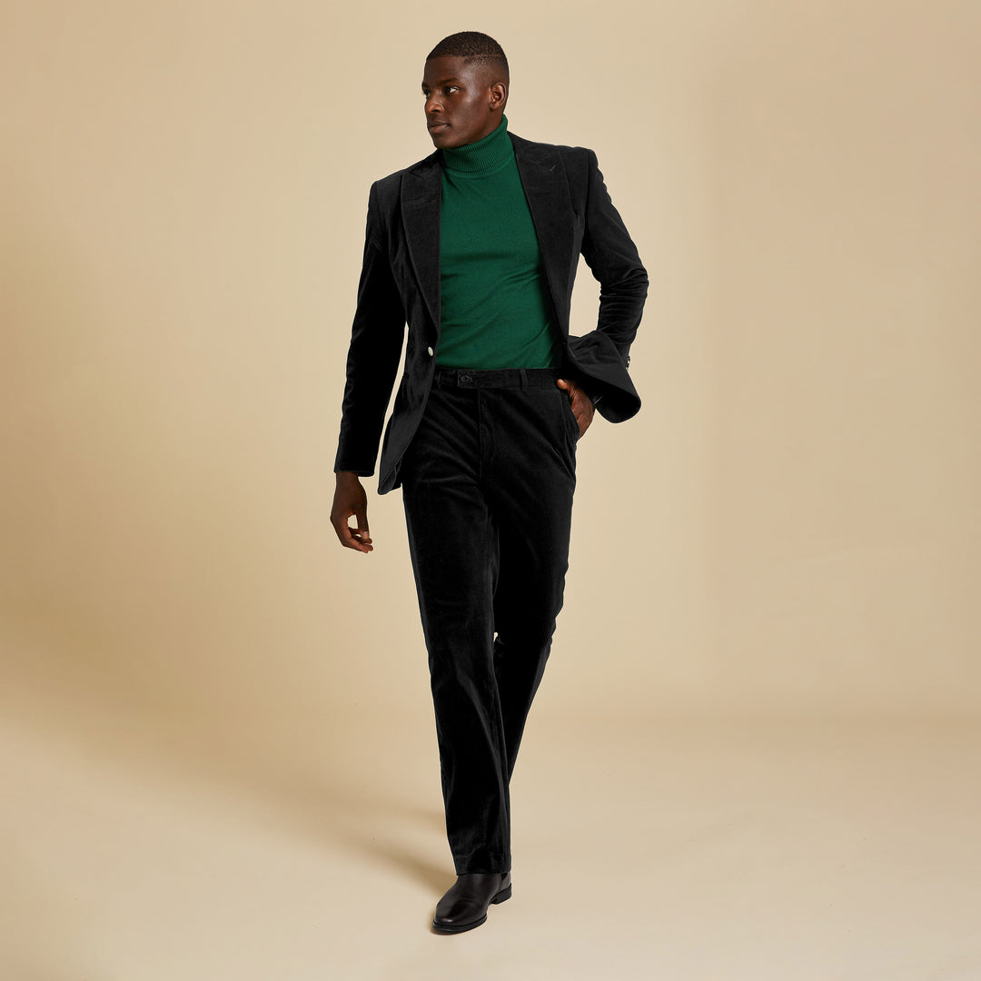 A person in the Inserch Velvet Blazer BL007-01 Black walks confidently against a plain beige background.