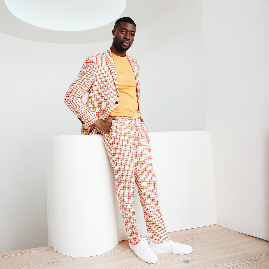 A person confidently stands against a plain background, adorned in the Inserch Houndstooth Linen Blazer BL279-00035 Rust and a vibrant red shirt.