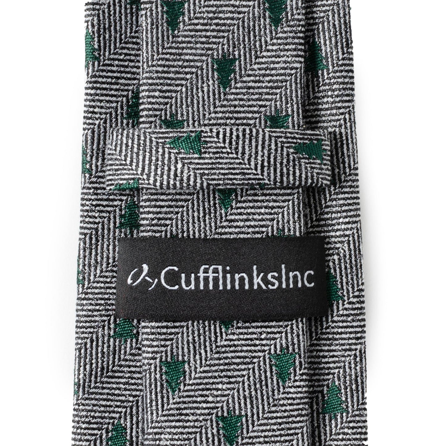 The Holiday Tree Herringbone Tie by Cufflinks.com features a black and white herringbone pattern adorned with small green tree motifs for a subtle, stylish look.