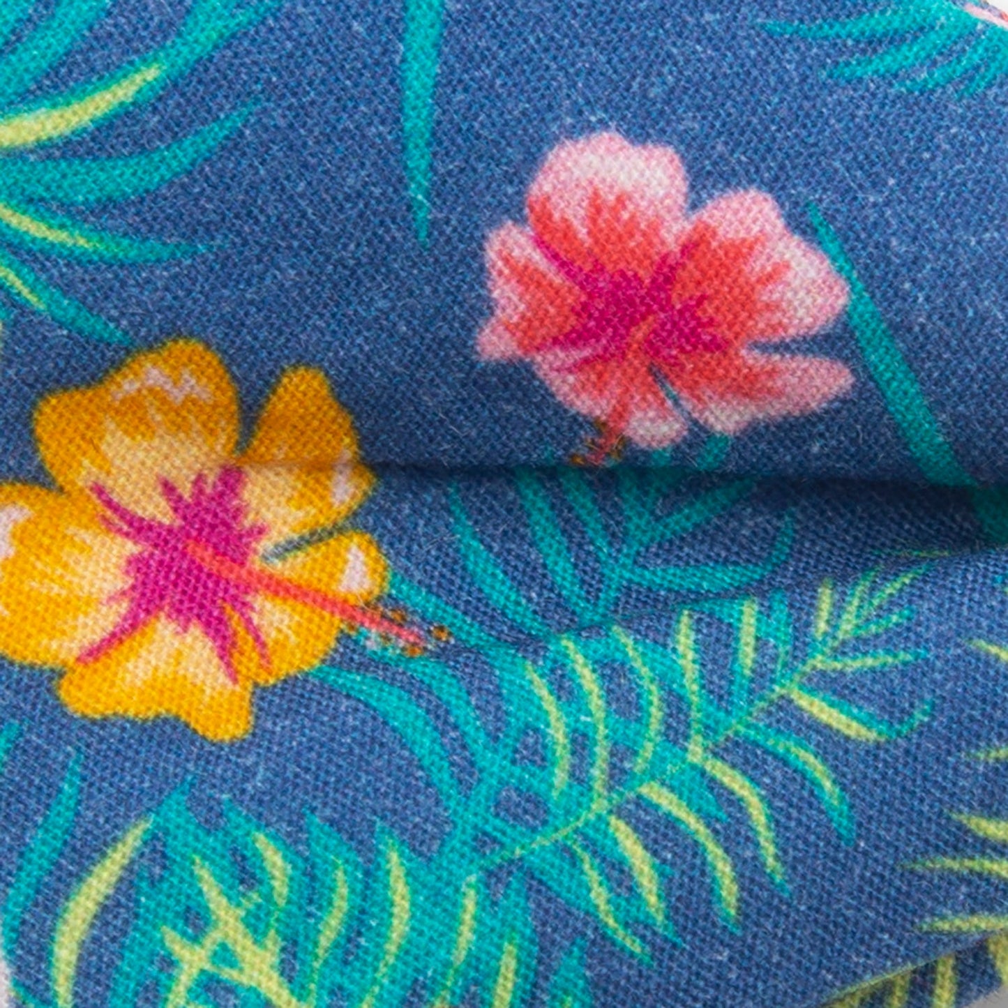 The Tropical Multi Men’s Bow Tie by Cufflinks.com features a colorful floral pattern with pink, yellow, and red flowers, green palm leaves, and vibrant hibiscus accents.