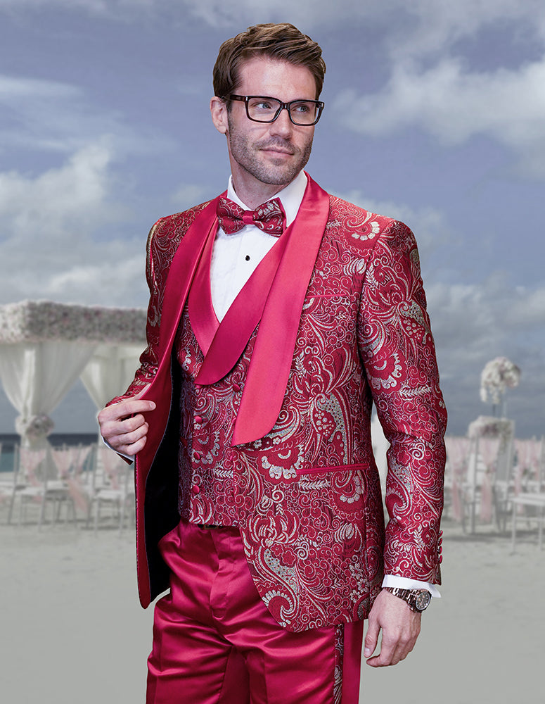 A man stands outdoors against a cloudy sky, wearing the Statement Clothing DELANO-4-RED Tuxedo (52R ONLY) in red and silver with a shawl lapel, modern fit, and matching bow tie.
