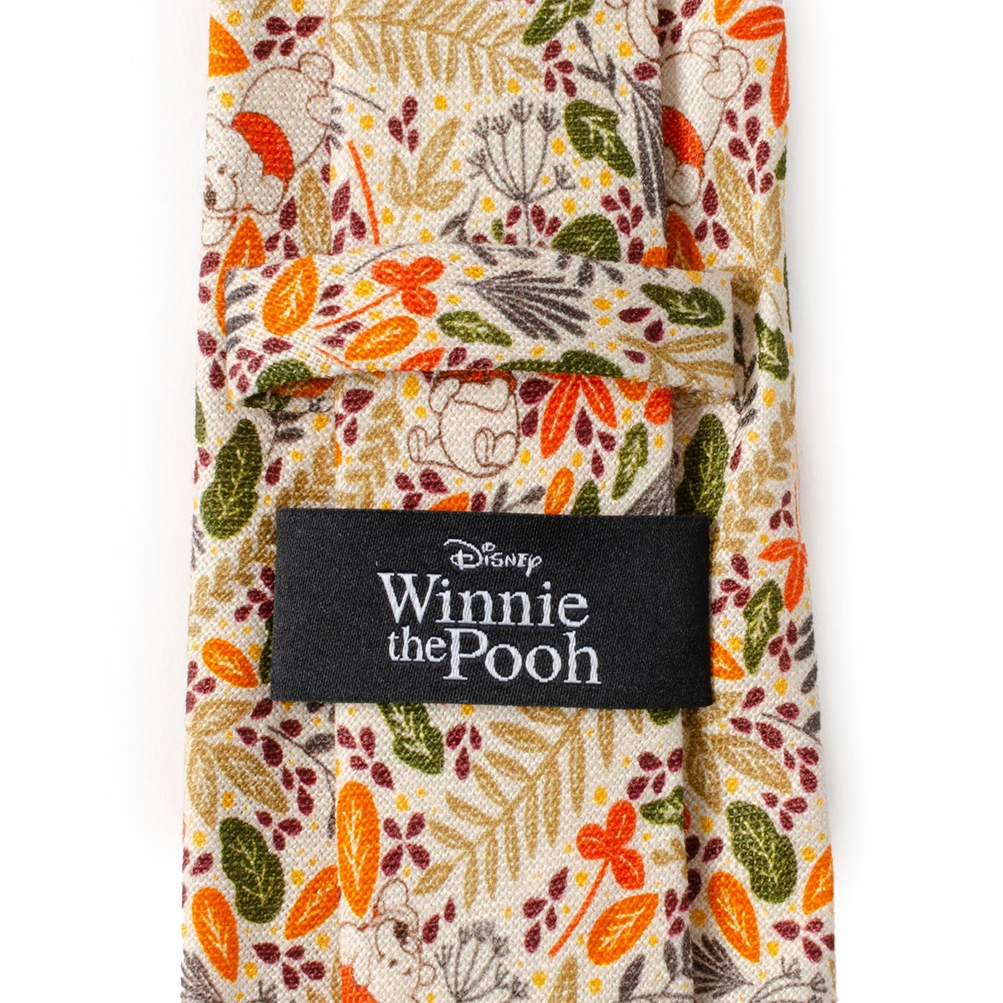 The Disney Winnie the Pooh Tan Patterned Men's Tie by Cufflinks.com features a beige background with autumn leaves in orange, yellow, green, and brown, plus subtle animal illustrations.