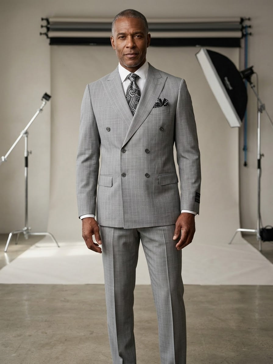 A man wearing the Tiglio Luxe PISTOIA Modern Fit Double Breasted Suit TL26048 by Tiglio poses in a photography studio, surrounded by professional lighting equipment and a backdrop.