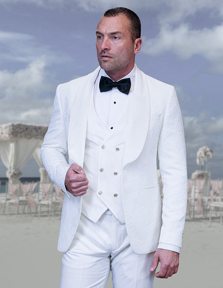 A man wearing the STATEMENT CLOTHING | EMPORIO-WHITE by Statement Clothing stands outdoors, surrounded by decorated chairs and floral arrangements.