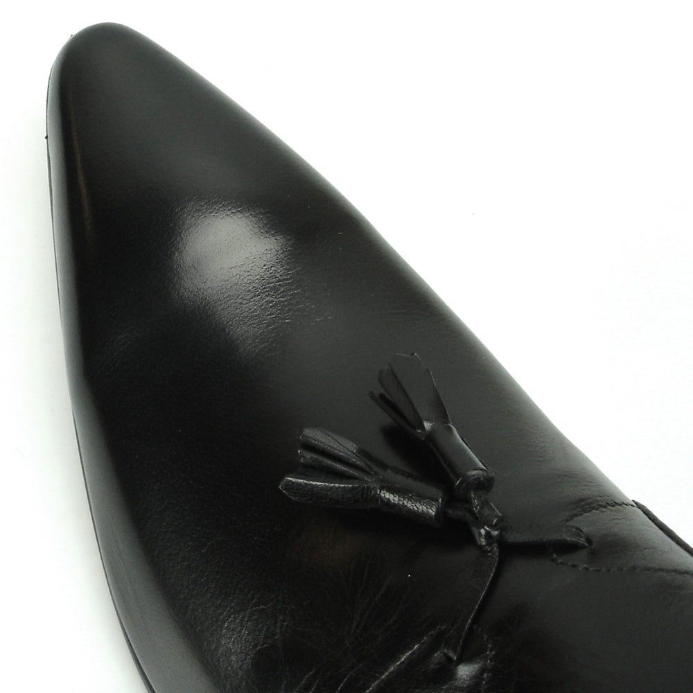 The FI-7287 Black Leather Slip On With Tassel by Fiesso features a pointed toe, low heel, and elegant tassels, inspired by men’s fashion. Displayed on a white background, this loafer adds sophistication to your style.