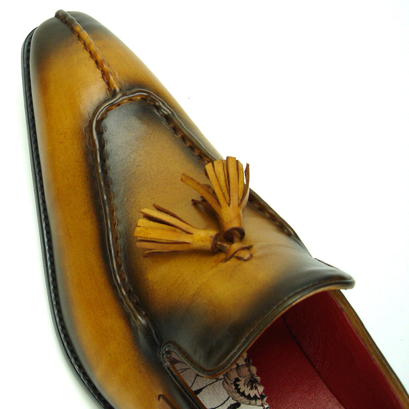 The FI-8701 Tan Encore by Fiesso is a handcrafted men’s leather loafer in brown, with tassels, darker shading on the toe and heel, and a red interior lining.