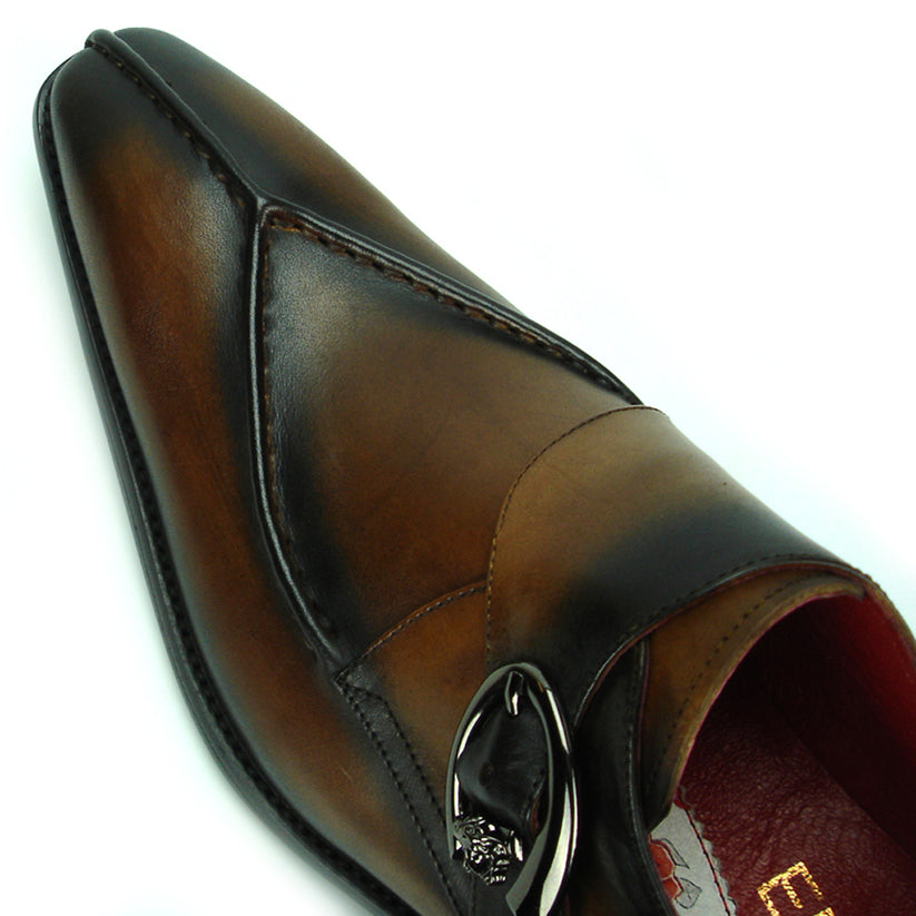 FI-8712 Coffee Encore by Fiesso—this handcrafted men’s dress shoe features rich brown leather, a pointed toe, black accent panels, a sleek side buckle, and a low heel. Displayed against a white background, it exemplifies the distinguished elegance of the Fiesso brand.