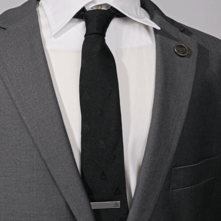 The Harry Potter Deathly Hallows Tie by Cufflinks.com is a black silk tie with a subtle, repeating pattern of small triangle symbols.