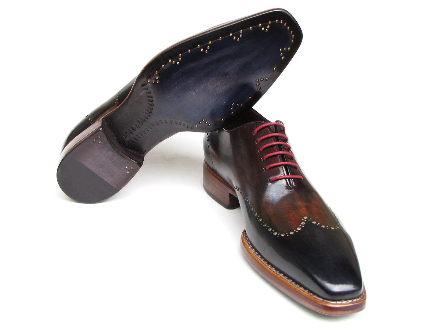 The Paul Parkman Wingtip Oxford Goodyear Welted Navy Red Black - 081-MIX features polished, handmade craftsmanship with a unique blend of navy, red, and black hues, complemented by red laces and decorative perforations. This classic wingtip oxford by Paul Parkman exudes timeless elegance.