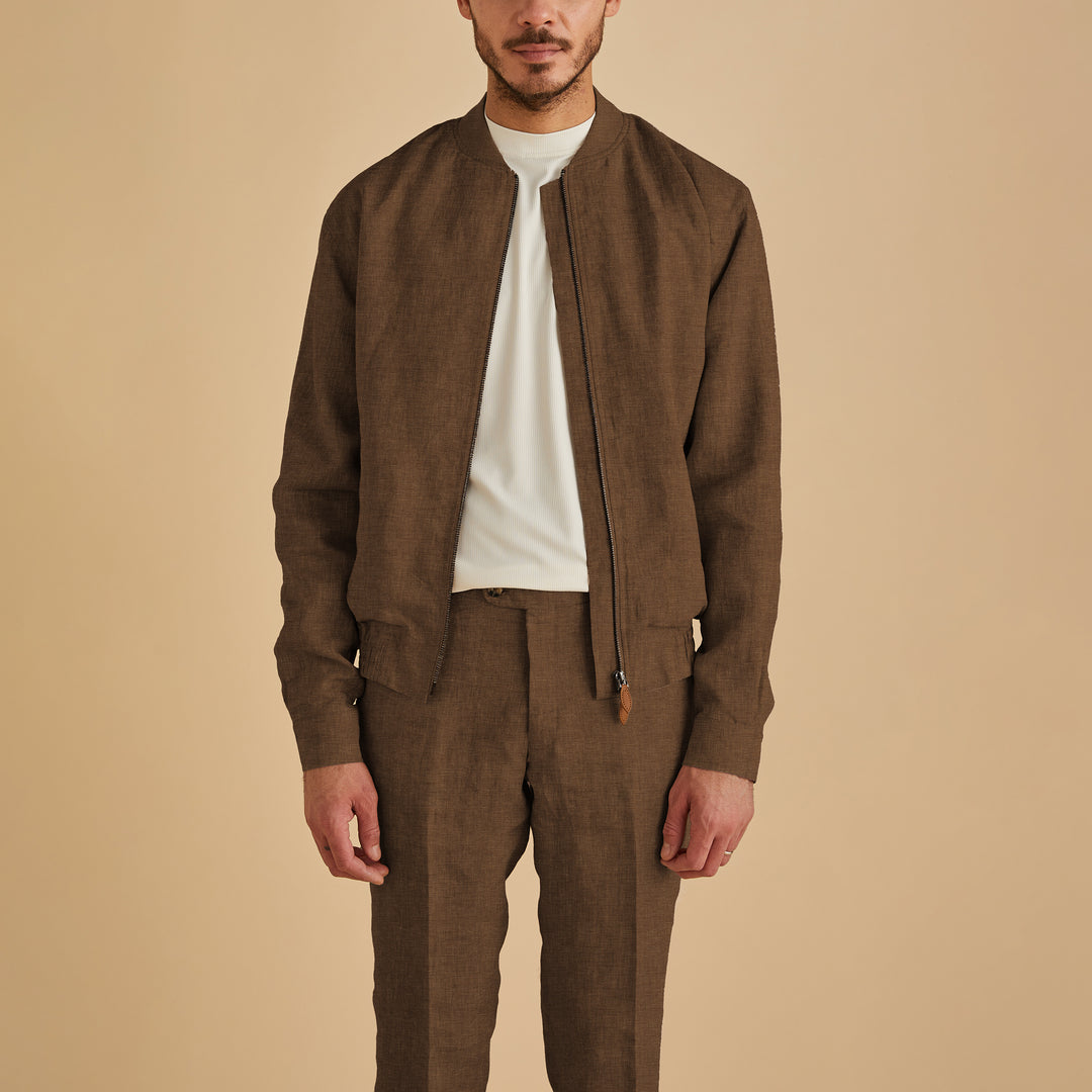A man wears the Inserch Linen Bomber Jacket JS660-00064 Mocha by Inserch with matching trousers and a white shirt, standing against a beige background.