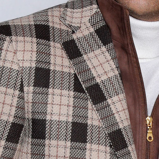 A man wearing the Insomnia MANZINI MZW-536 brown tailored fit faux wool plaid blazer coat with a zip-out liner and a white turtleneck is paired with blue jeans, standing against a light gray, textured backdrop.