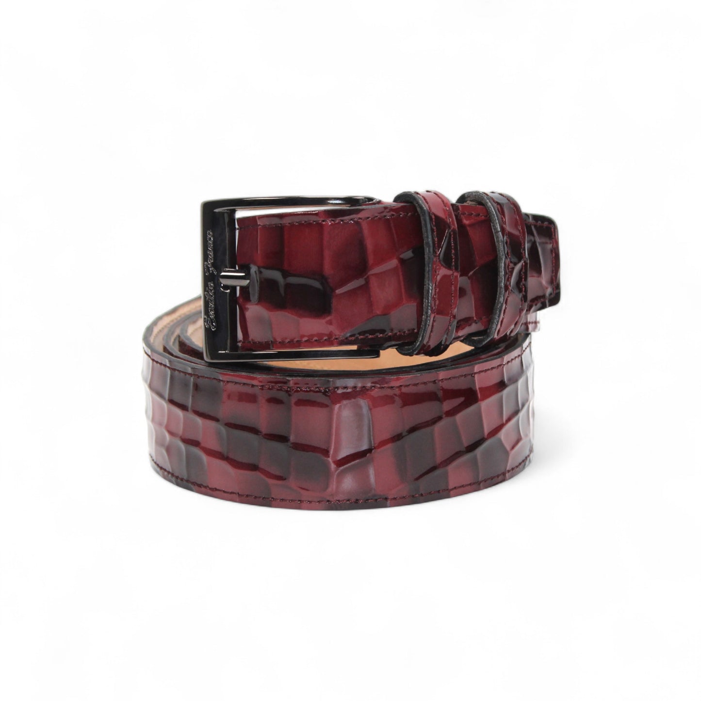 The Matiste Burgundy Leather Belt NS1 by Matiste features a maroon crocodile-patterned Italian leather and a bold metallic buckle with a raised lion head, bringing luxurious style to any outfit.