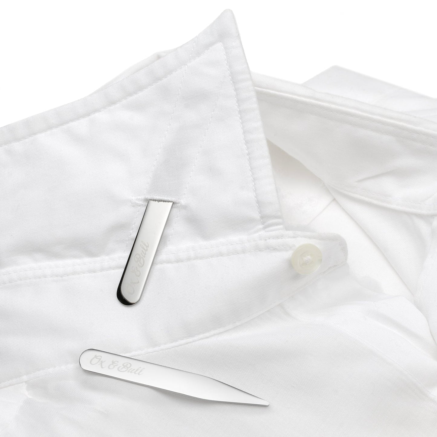 Two Stainless Steel Engravable Collar Stays by Cufflinks.com lie parallel on a white background, adding a sleek, personalized touch to any shirt.