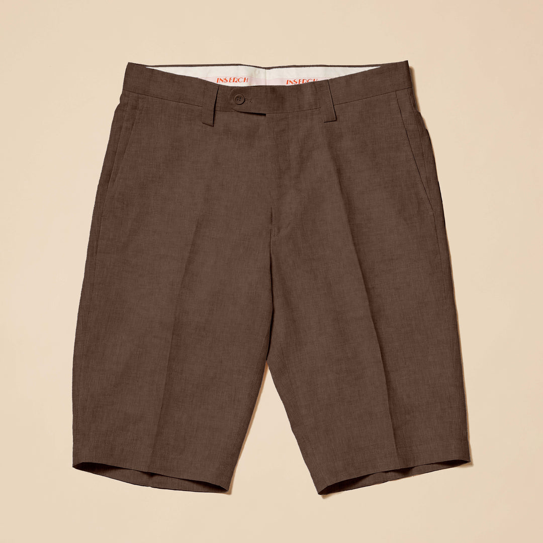 Inserch Premium Linen Flat Front Shorts (P21116-00024) in chocolate brown, knee-length with a modern fit, front zipper, and belt loops are laid flat on a beige background.