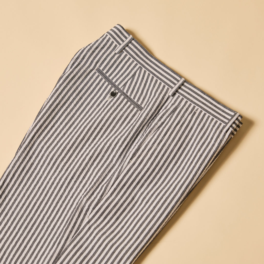 The Inserch Seersucker Stripe Pants (P660155-00001 Black) with a modern fit are folded neatly on a beige background.