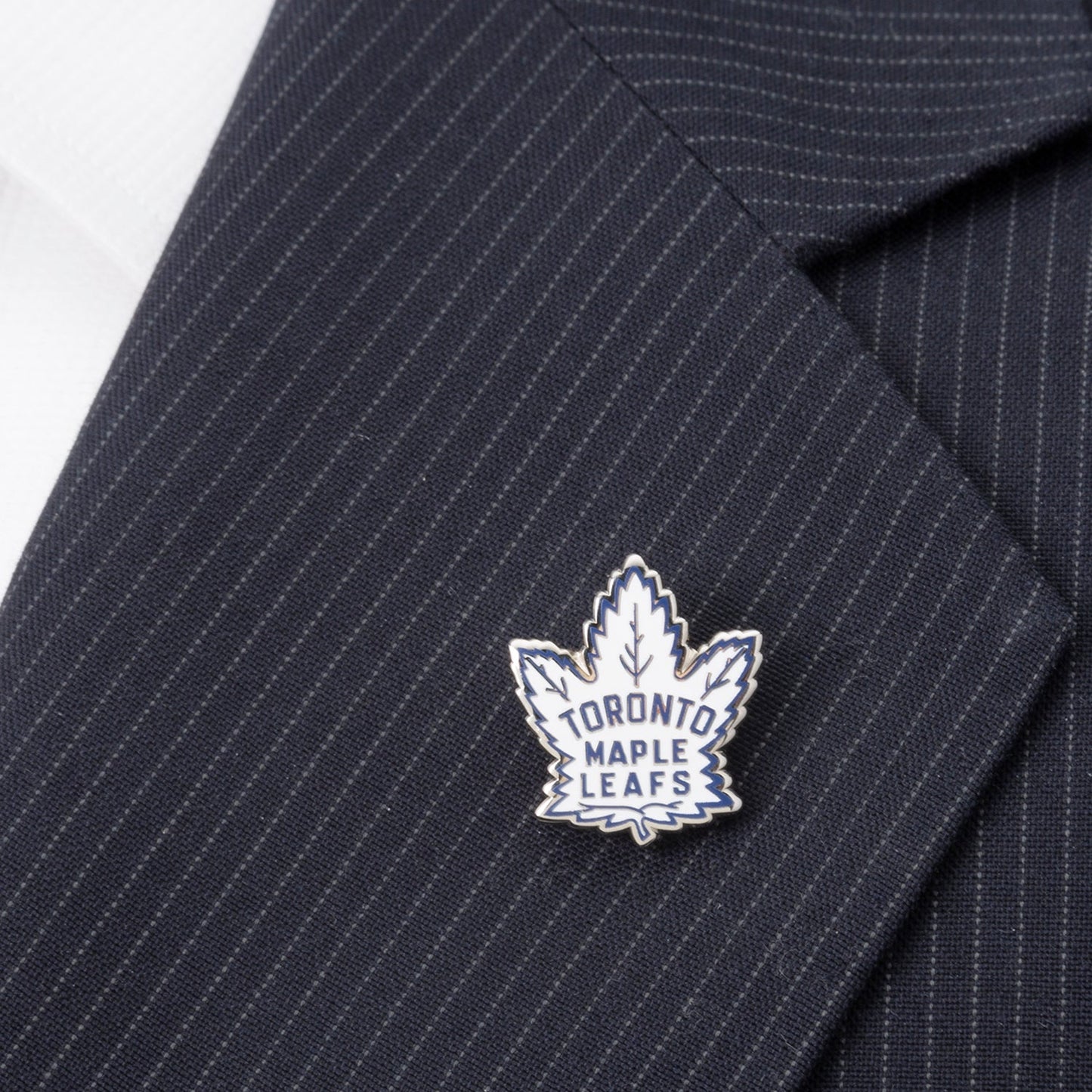 The Cufflinks.com NHL Toronto Maple Leafs Throwback Lapel Pin features a classic maple leaf design in silver and white with bold blue "Toronto Maple Leafs" lettering—perfect for any fan or collector.