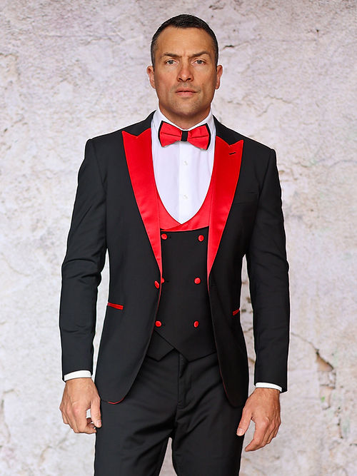 A man faces forward in the Insomnia MANZINI ROME 3-Piece Slim Fit Stretch Spandex Black/Red Tuxedo Suit, featuring a black jacket, red accents, vest, and bow tie against a light textured background.