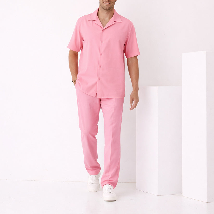 A man stands in a minimal white room wearing the Inserch Crepe Camp Collar Shirt SE9356-00057 in Summer Pink, paired with matching pants and white sneakers.