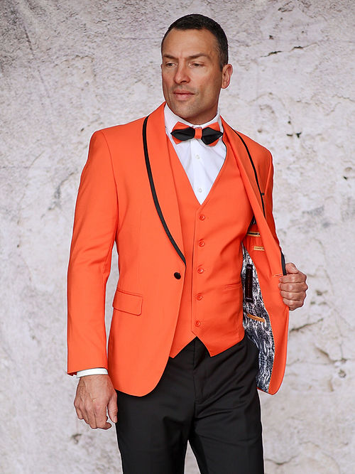 A person confidently stands against a textured background wearing the MANZINI SUNSET Slim Fit 3-Piece Orange Black Tuxedo Suit with Reversible Vest and matching bow tie by Insomnia.