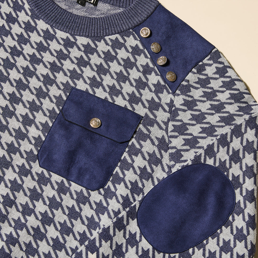 Man wearing the Inserch Houndstooth Crew Neck Sweater SW002-11 Navy Blue by Inserch, featuring blue and white houndstooth pattern, military shank buttons on the shoulder, chest pocket, accent panels, and paired with gray pants.