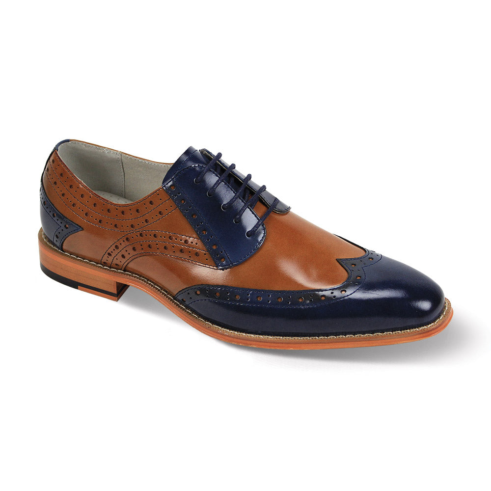 The Giovanni Troy Navy/Tan Leather Shoes by GIOVANNI are elegant brogues featuring a classic wingtip design in brown and navy. With decorative perforations and a lace-up closure, they offer timeless appeal and modern sophistication.