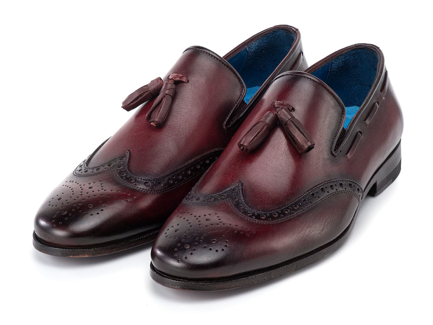 The Paul Parkman Wingtip Tassel Loafers Bordeaux (WL34-BRD) are men's hand-painted calfskin loafers in burgundy, featuring perforated detailing, blue inner lining, and displayed on a white background.