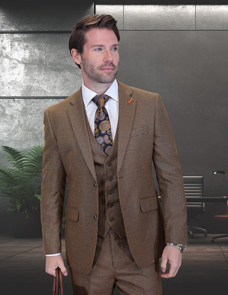 A man in the STATEMENT CLOTHING | ZILONI-3-COPPER modern fit Italian wool suit by Statement Clothing and a paisley tie stands in a contemporary office with dark walls, office furniture, and a plant in the background.