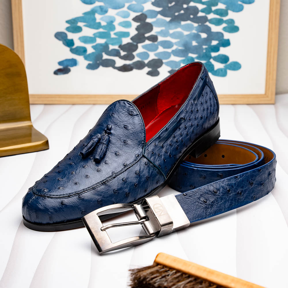 The Domenico Belt Navy by Marco Di Milano is crafted from blue ostrich leather, features a silver buckle engraved with the brand’s logo, and makes an elegant match for their luxury footwear.