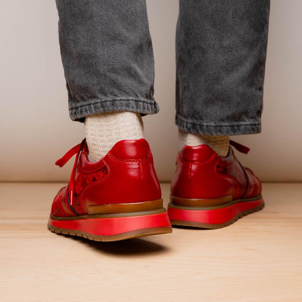 The Marco Di Milano Brescia Red sneakers feature red leather with a python-inspired texture, rubber sole, and lace-up design—shown with one shoe upright and the other displaying the sole.