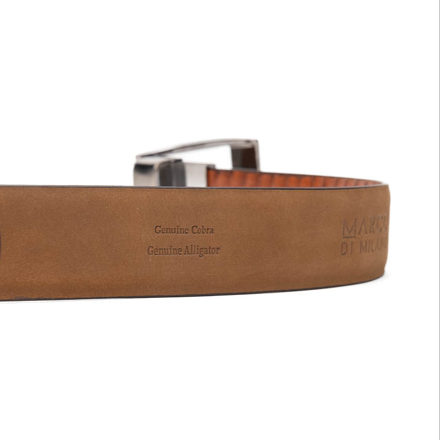 The Moncalieri Belt Brown/Cognac by Marco Di Milano features textured leather, a silver buckle engraved with "Marco Di Milano" and "MD," and is coiled against a white background—crafted to complement their luxury footwear and exotic skin belts.