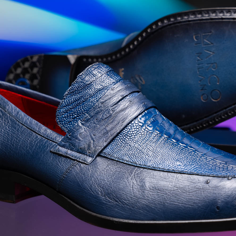 The Marco Di Milano Fangio Denim Blue features genuine ostrich loafers with textured blue uppers and red lining—one upright, one on its side displaying the sole—a standout addition to any luxury men’s footwear collection.