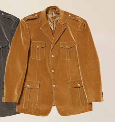 A gentleman wearing the Inserch Velvet Military Blazer BL569-184 in Brown Sugar, accompanied by a patterned sweater, jeans, and brown sneakers, stands and smiles against a beige background.