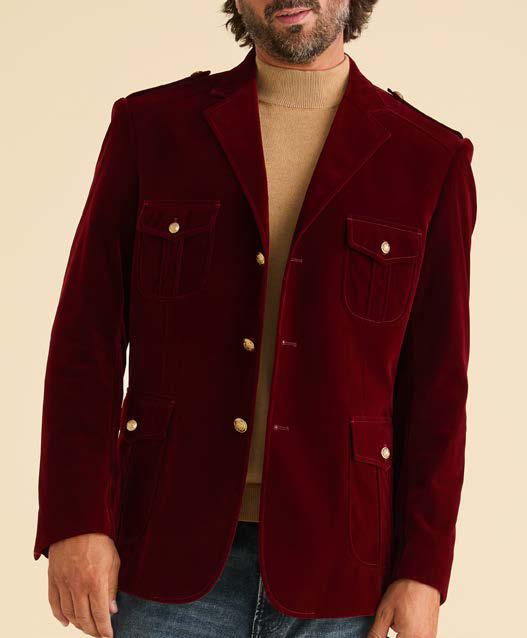 A man wearing the Inserch Velvet Military Blazer BL569-00031 in Burgundy, featuring gold military shank buttons, over a tan turtleneck and paired with blue jeans.