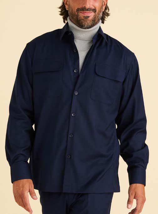 A man wears the Inserch Two-Pocket Shirt SE004-00006 Ink by Inserch—a navy blue, regular fit, long sleeve shirt—styled unbuttoned at the top over a light gray turtleneck for a relaxed look.